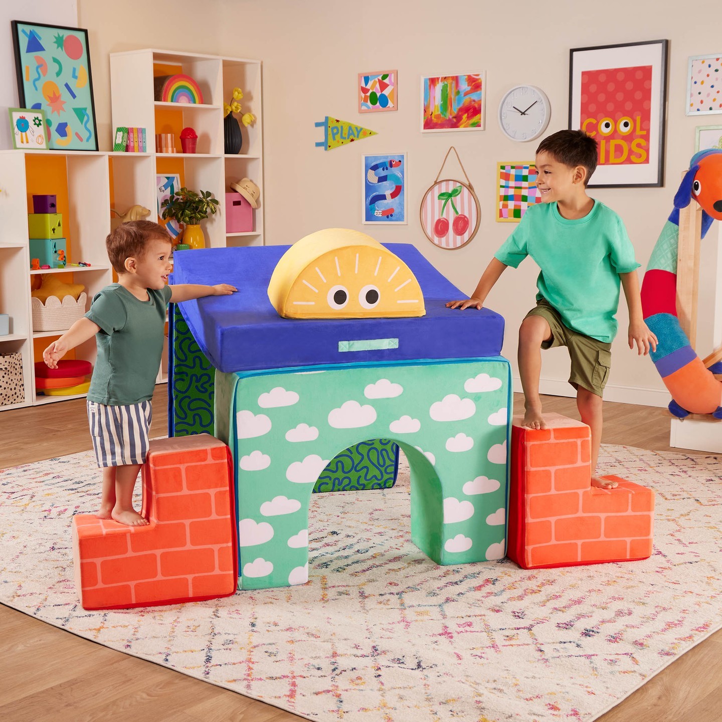 Two toddlers playing on foam play shapes in shape of castle or fort