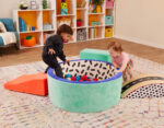 two toddlers playing in a vibrant foam ball pit