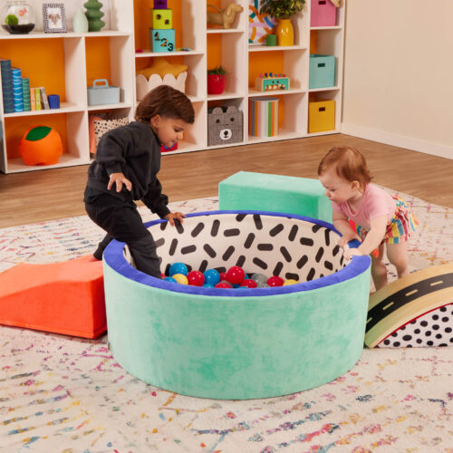 two toddlers playing in a vibrant foam ball pit