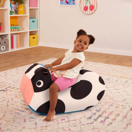 Child sitting and rocking on foam cow